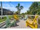 Waterfront deck with colorful Adirondack chairs overlooking lush backyard and canal at 1446 Stone Trl, Enterprise, FL 32725