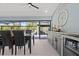 Elegant dining area with black table and chairs, wine cooler, and sliding glass doors to the outdoor patio at 1446 Stone Trl, Enterprise, FL 32725
