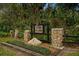 Community entrance sign with stone accents surrounded by lush greenery at 1446 Stone Trl, Enterprise, FL 32725