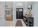 Foyer with dark front door, stylish console table and open living space at 1446 Stone Trl, Enterprise, FL 32725