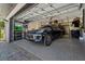 Inside the garage, a luxury car is parked on the epoxy flooring next to wall-mounted shelves and organizers at 1446 Stone Trl, Enterprise, FL 32725