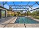 The screened-in pool area also includes a set of stairs, a water feature, and a view of the backyard and surrounding neighborhood at 1446 Stone Trl, Enterprise, FL 32725