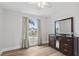 Bedroom featuring hardwood floors, a window with curtains, and a dresser at 1491 Nappa Dr, Port Orange, FL 32128
