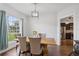 Cozy dining area with hardwood floors, a view to the kitchen, and a large window with natural light at 1491 Nappa Dr, Port Orange, FL 32128