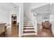 Bright foyer with hardwood floors leading to a staircase, living room, and glimpses of a modern kitchen at 1491 Nappa Dr, Port Orange, FL 32128