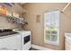 Well-equipped laundry room boasts a modern washer and dryer, storage shelves, and a window for natural light at 1491 Nappa Dr, Port Orange, FL 32128