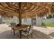 Cozy tiki bar area, perfect for entertaining, featuring a thatched roof, seating, and a grill for outdoor fun at 1491 Nappa Dr, Port Orange, FL 32128