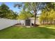 Well-maintained backyard featuring green grass, a storage shed, privacy fence, landscaping, and mature shade trees at 1523 Red Plum Holw, Deland, FL 32720