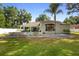Beautiful home with a well-manicured lawn, palm trees, and a charming blue front door at 1523 Red Plum Holw, Deland, FL 32720