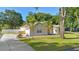 Charming single-story home with a well-manicured lawn, mature trees, and a long driveway leading to the garage at 1523 Red Plum Holw, Deland, FL 32720