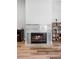 Close up of a fireplace with modern tile, featuring a lit fire and a bookshelf next to it at 1523 Red Plum Holw, Deland, FL 32720