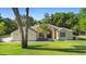 Inviting single-story home with a manicured lawn and blue front door, nestled in a lush, tree-filled landscape at 1523 Red Plum Holw, Deland, FL 32720