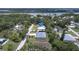 An aerial view featuring a home with a gray roof near waterfront in a tree-lined neighborhood at 156 N Cory Dr, Edgewater, FL 32141
