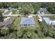 An aerial perspective of a gray roofed home on a large lot with a long driveway, surrounded by lush greenery at 156 N Cory Dr, Edgewater, FL 32141