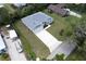 Aerial view of a new, well-manicured home featuring a gray roof, and a long driveway leading to a three-car garage at 156 N Cory Dr, Edgewater, FL 32141