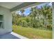 Backyard view with lush trees and grass seen from a shaded patio at 156 N Cory Dr, Edgewater, FL 32141