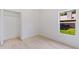 Bright bedroom with wood flooring, closet, and a window with a view of greenery at 156 N Cory Dr, Edgewater, FL 32141