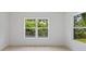 Bright bedroom featuring large windows offering lush greenery views and light wood flooring at 156 N Cory Dr, Edgewater, FL 32141