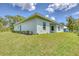 A lovely single-story home with well-maintained green lawn and trimmed hedges beneath clear blue skies at 156 N Cory Dr, Edgewater, FL 32141