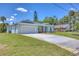 Exterior of home with a two-car garage, long driveway and lush green lawn at 156 N Cory Dr, Edgewater, FL 32141
