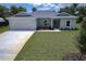 Charming single-story home with a two-car garage, manicured lawn, and freshly planted landscaping at 156 N Cory Dr, Edgewater, FL 32141