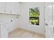 Bright laundry room with white cabinetry, modern fixtures and outside view at 156 N Cory Dr, Edgewater, FL 32141