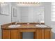 Bathroom featuring double sinks with wood cabinets and a large mirror, with the shower in the background at 15733 Green Point Ct, Clermont, FL 34714