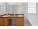 Bathroom featuring double sinks with wood cabinets and a block glass window at 15733 Green Point Ct, Clermont, FL 34714