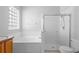 Bathroom featuring a combined bathtub and shower with glass doors, and a block window at 15733 Green Point Ct, Clermont, FL 34714