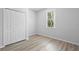 Bright bedroom with hardwood floors, a window, and a double door closet at 15733 Green Point Ct, Clermont, FL 34714