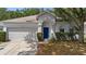 Charming one-story home with a two-car garage, blue front door, and landscaped yard at 15733 Green Point Ct, Clermont, FL 34714