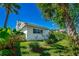 Serene backyard showcasing a well-manicured lawn, a wooden fence, and tropical foliage creating a private and relaxing outdoor space at 1613 Crescent Ridge Rd, Daytona Beach, FL 32118