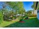 Lush backyard featuring mature trees, plants and green grass alongside a wooden deck, providing privacy and a tranquil outdoor space at 1613 Crescent Ridge Rd, Daytona Beach, FL 32118