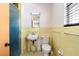 Bathroom featuring vintage yellow tile, a sink, toilet, and shower stall with blue door at 1613 Crescent Ridge Rd, Daytona Beach, FL 32118