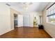 Bedroom with hardwood floors, ceiling fan, closet, and adjacent bathroom and hallway access at 1613 Crescent Ridge Rd, Daytona Beach, FL 32118