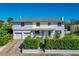 Charming two-story home boasts a crisp white facade, complemented by manicured greenery and a vibrant turquoise front door at 1613 Crescent Ridge Rd, Daytona Beach, FL 32118