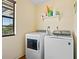 Laundry room with side-by-side white washer and dryer at 1613 Crescent Ridge Rd, Daytona Beach, FL 32118