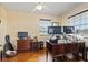 Office featuring a large wooden desk, hardwood floors, and natural light from two windows at 1613 Crescent Ridge Rd, Daytona Beach, FL 32118