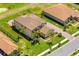 Aerial view of a well-maintained home with a brick driveway, tile roof, and beautifully landscaped yard with palm trees at 163 Rosa Bella Vw, Debary, FL 32713