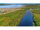 Breathtaking aerial view of homes near a river surrounded by dense, green trees, with a large lake in the distance at 163 Rosa Bella Vw, Debary, FL 32713