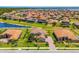 Community aerial showcasing tile-roofed homes surrounding a peaceful lake, blending residential living with natural beauty at 163 Rosa Bella Vw, Debary, FL 32713