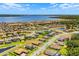 Wide aerial view of a neighborhood with single-Gathering homes, roads, ponds, and a large lake in the background at 163 Rosa Bella Vw, Debary, FL 32713
