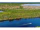 Scenic aerial shot of a neighborhood situated near a lake with lush trees, a waterway and a passing boat at 163 Rosa Bella Vw, Debary, FL 32713