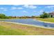 Scenic backyard view featuring a tranquil pond surrounded by lush greenery and neighborhood homes at 163 Rosa Bella Vw, Debary, FL 32713