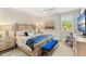 Bright bedroom with a large bed, a blue bench, and a window with natural light at 163 Rosa Bella Vw, Debary, FL 32713