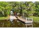 Scenic boat ramp featuring a dock, walkway, and lush, green trees creating a tranquil waterfront setting at 163 Rosa Bella Vw, Debary, FL 32713