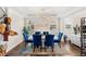 Bright dining room with a white table, blue chairs, modern lighting, and hardwood floors at 163 Rosa Bella Vw, Debary, FL 32713