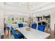 Open-concept dining area with blue chairs, a white table, and views of the living room and kitchen at 163 Rosa Bella Vw, Debary, FL 32713