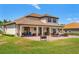 Beautiful backyard featuring a large brick patio with ample seating and lush green lawn, perfect for outdoor entertaining at 163 Rosa Bella Vw, Debary, FL 32713