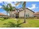 Stunning home showcasing lush landscaping, a well-manicured lawn, and mature palm trees at 163 Rosa Bella Vw, Debary, FL 32713